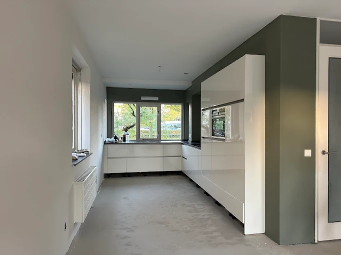 Opgeleverde keuken met witte wanden en groen kleuraccent