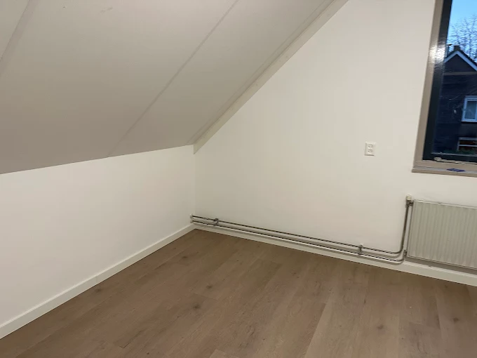 Schilder rolt latex op een egale wand in een woning